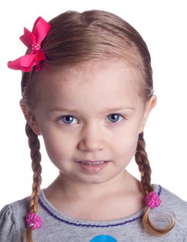 A young girl with a cute smile and pink bows.