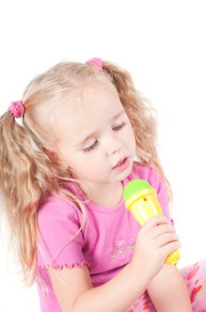 Little cute girl in pink and with ponytails in studio