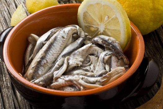 anchovies with olive oil and lemon on a bowl