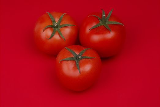 Group of red tomatos on red background