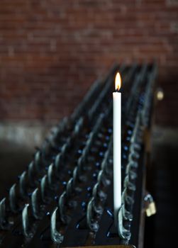 Lonely candle in a Italian Abbey. Concept of hope, faith, loneliness