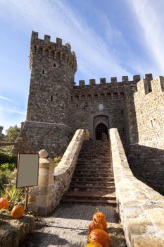 The entrance to a stone castle with pumpkins