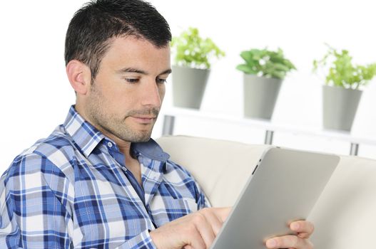 attractive relaxed and positive man is surfing on his tablet