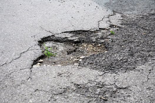 pothole road damage or pot hole concept with street