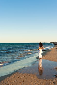 Hispanic woman enjoying beach walk on a mild sunny afternoon