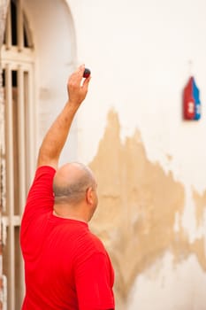 Traditional Spanish pelota player holding up the ball before proceeding to serve