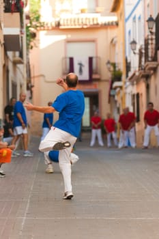 Action on a village street where a traditional Spanish pelota match is taking place