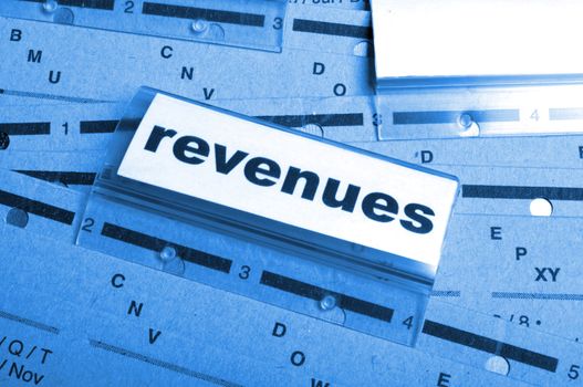 revenue or revenues word on business office folder showing financial success