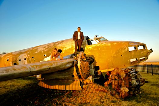 sexy young adult wedding couple standing at crashed DC3 Dakota war plane