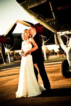 sexy young adult wedding couple standing with old war Albatross aircraft