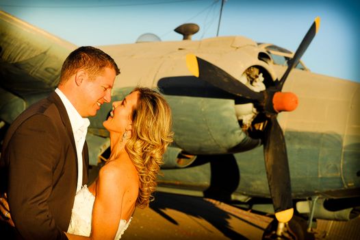 sexy young adult wedding couple standing with old war Albatross aircraft