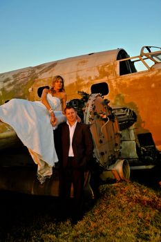 sexy young adult wedding couple standing at crashed DC3 Dakota war plane