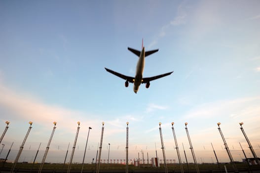 Plane is flying over landinglights. Note that the lights is in focus and the plane is in motion blure because of the speed.
