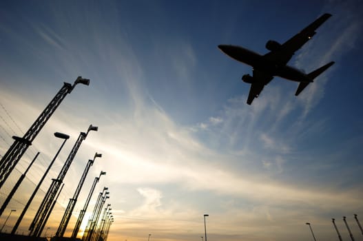 Plane is going to land in an airport. The plane is a bit in motion blur because of the speed.