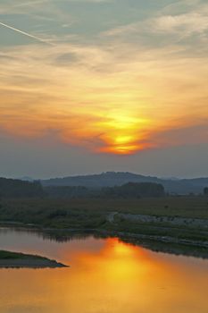 Beautiful orange sunset on the river, vertical image