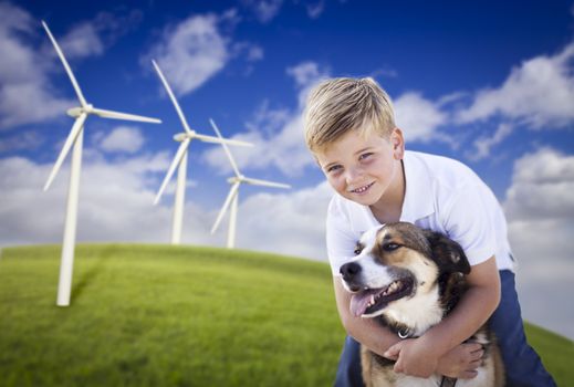 Handsome Young Blue Eyed Boy and Dog Playing Near Wind Turbines and Grass Field.