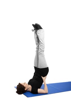 young woman exercising shoulder stand on blue mat