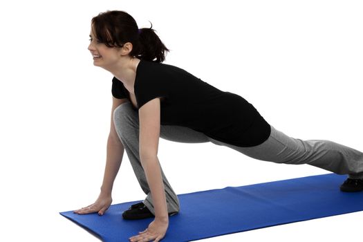 young woman exercising gymnastics on blue mat