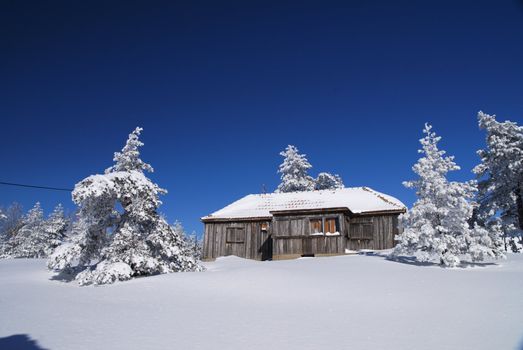 Mountain house in snow, winter sunny day