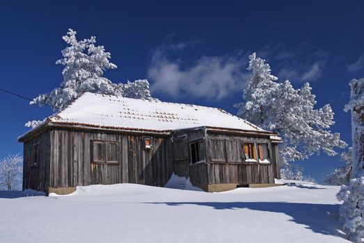 Mountain house in snow, winter sunny day