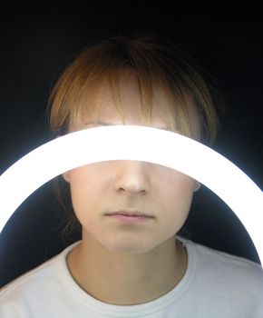 View of a young woman with light arc over her eyes 