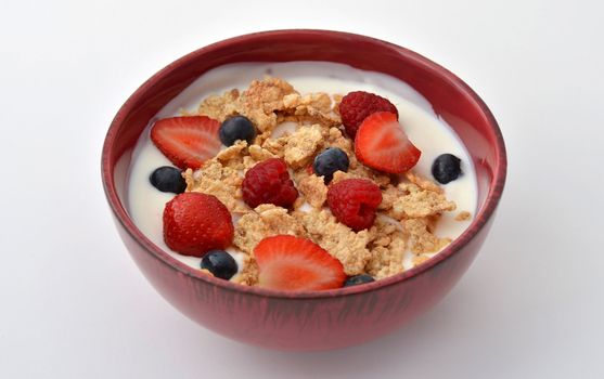 Breakfast bowl with yogurt, cereal, strawberries, blueberries and raspberries