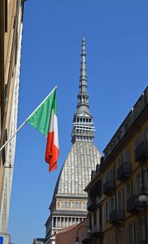 Mole Antonelliana and italian flag in bright daylight