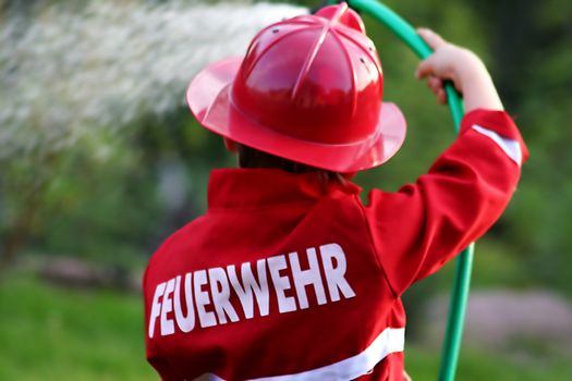 little fire man in the garden with the water hose