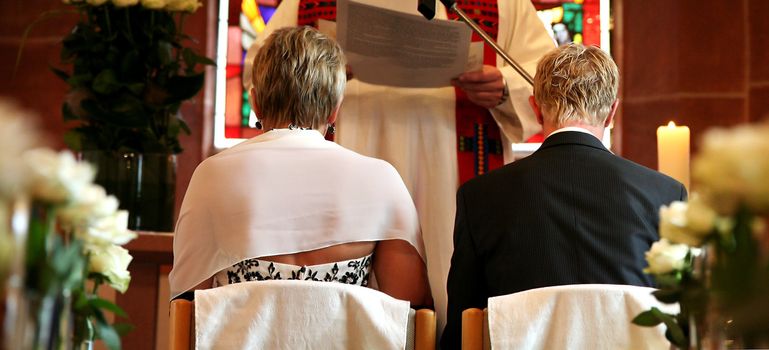 Bride and groom on chairs in the church