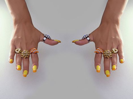 Hand showing big rings on fingers, colored nails