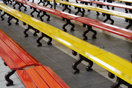 many yellow and red empty benches in a row