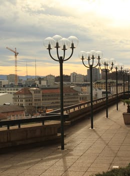Balcony with many lamps upon the city buildings by sunset