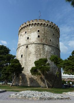 The white tower at Thessaloniki city in Greece surrounded with trees by beautiful weather