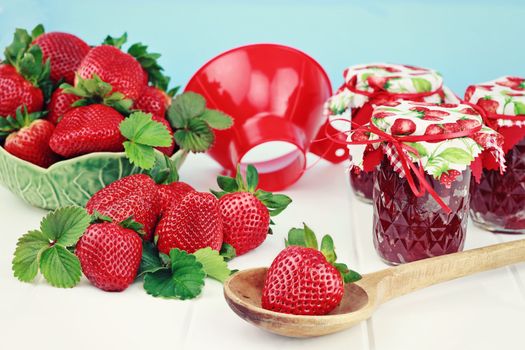 Fresh strawberries and preserves with canning funnel. Shallow DOF.