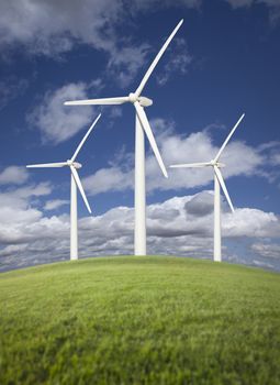 Three Wind Turbines Over Grass Field, Dramatic Sky and Clouds.