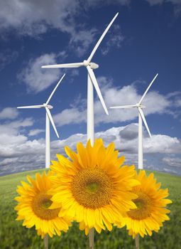 Wind Turbines Against Dramatic Sky, Clouds and Bright Sunflowers in the Foreground.
