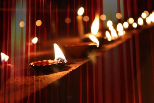 Beautiful diwali lamps traditionally lit on the occassion of Diwali festival in India, with beautiful red light streaks.