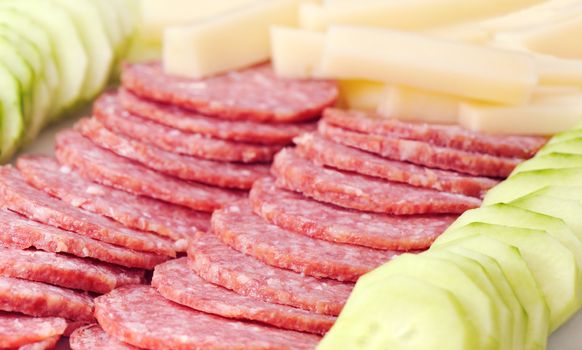 Plate with salami, cheese and cucumber appetizers