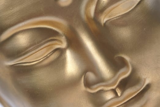 Diagonal close up of golden buddha face.                