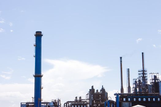 Factory with smoke stacks against blue sky