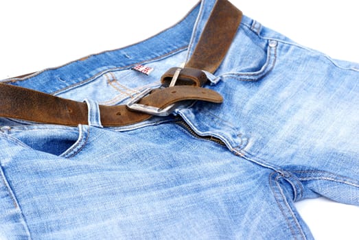 Isolated part of female jeans with brown leather belt.