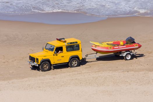 Rescue vehicle towing a rescue rubber dinghy on the beach