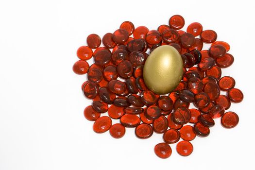 Golden egg set on red glass stone background