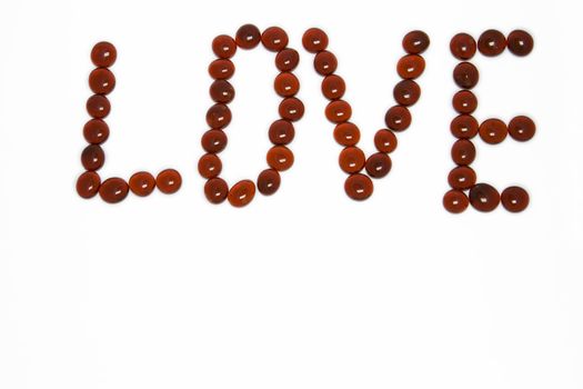 Love spelt in red gemstones on white background