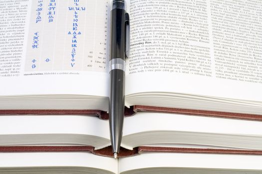 a pen lying on the pile of books - close up