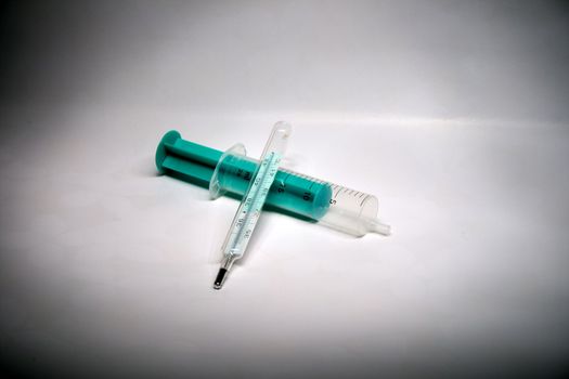 A clinical thermometer and a syringe- close up