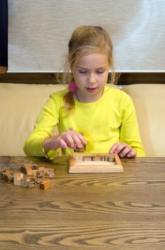 Portrait of the lovely girl collects a puzzle.