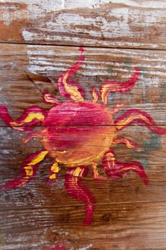 Grungy sun painted on old white washed wood