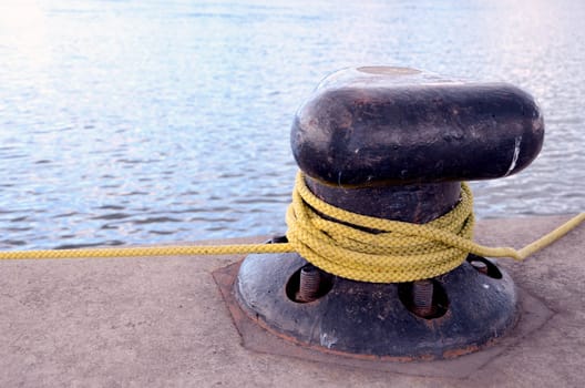 Thick rope rotated around mooring pole berth.