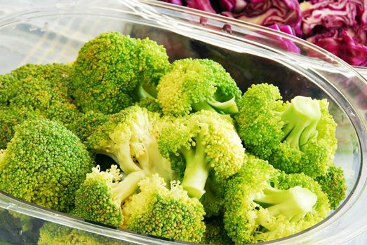 fresh green broccoli and magenta cabbage in steamer utensils